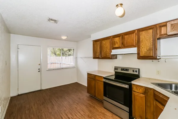 a kitchen with stainless steel appliances granite countertop a stove a sink and a microwave