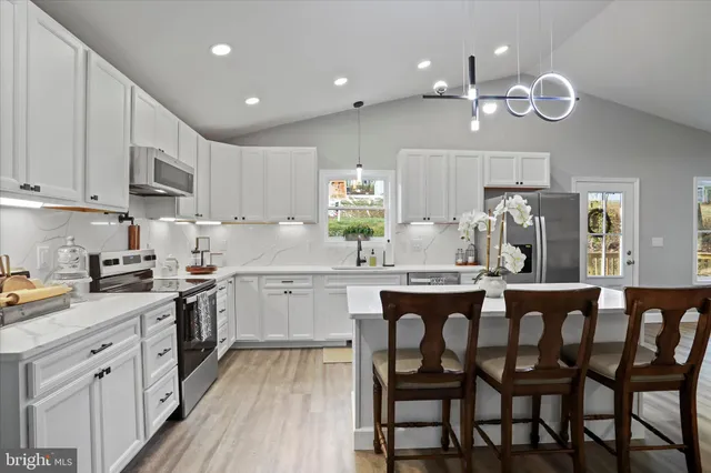 a view of a house with a yard and large tree