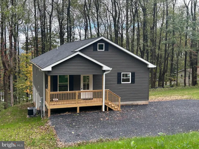 a view of a house with a yard and large tree