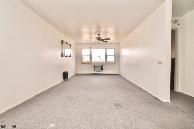 114 32nd Street, Unit 30 Union City, NJ 07087 - Photo 1 of 20 an empty room with windows and ceiling fan