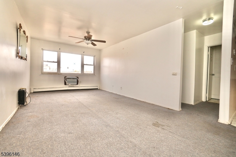 114 32nd Street, Unit 30 Union City, NJ 07087 - Photo 2 of 20 an empty room with windows and ceiling fan
