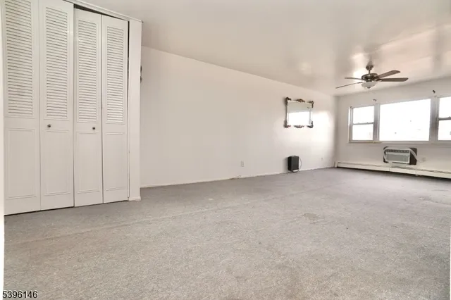 an empty room with windows and closet
