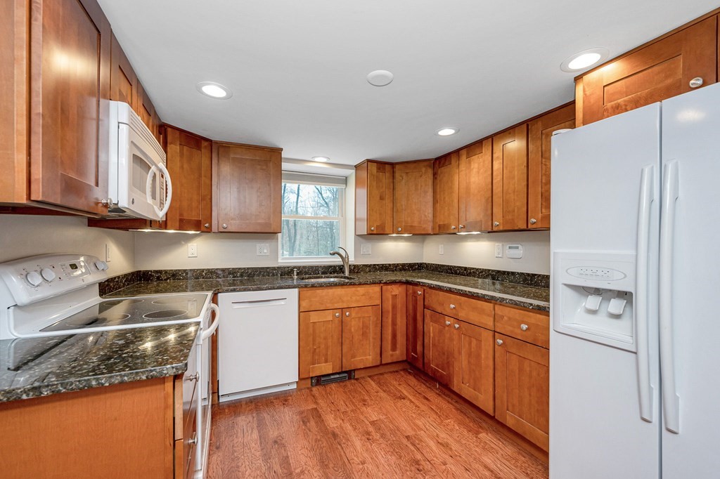 23 Lane Road Pelham, NH 03076 - Photo 16 of 42 a kitchen with stainless steel appliances granite countertop wooden cabinets granite counter tops and a hard wood floors