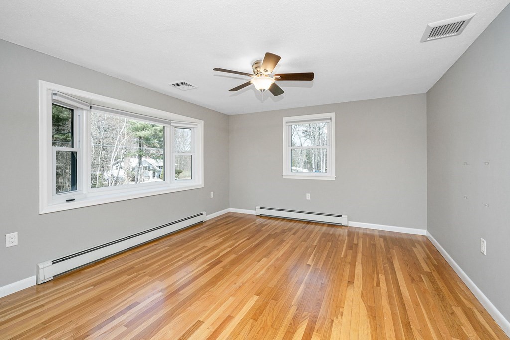 23 Lane Road Pelham, NH 03076 - Photo 4 of 42 a view of empty room with wooden floor and fan