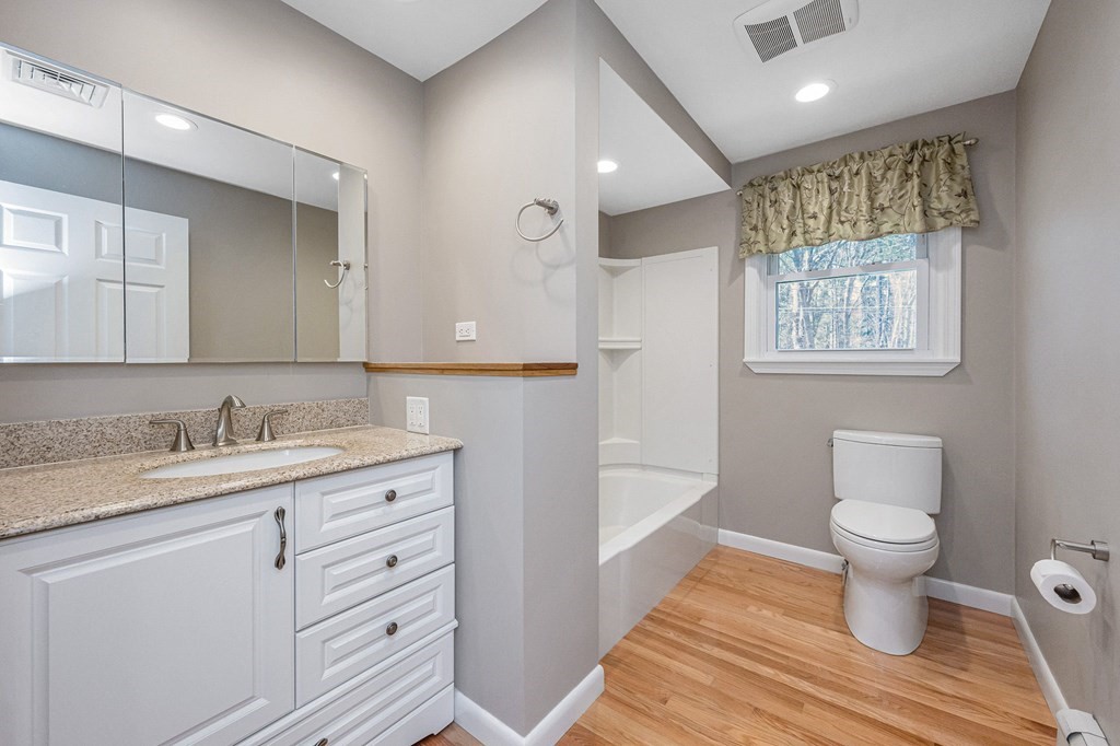 23 Lane Road Pelham, NH 03076 - Photo 10 of 42 a bathroom with a granite countertop toilet sink and mirror