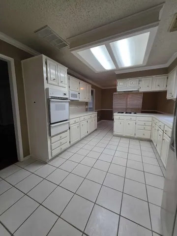 a kitchen with white cabinets a sink and white appliances