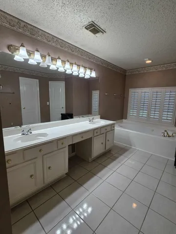 a bathroom with a double vanity sink a mirror and a bathtub