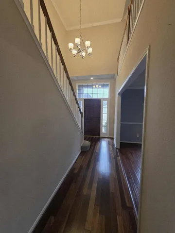 a view of a hallway with wooden floor and staircase