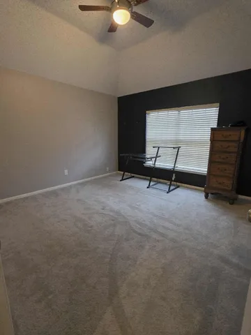 a view of a room with furniture and a ceiling fan