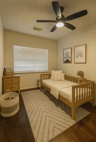 a bedroom with a bed and wooden floor