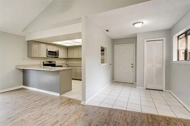 a view of a kitchen with wooden floor and a ceiling fan