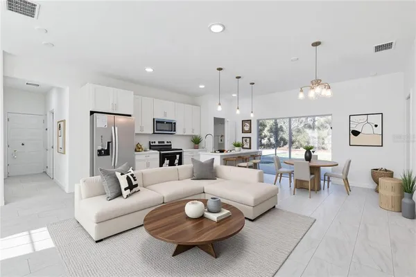 a kitchen with stainless steel appliances granite countertop a refrigerator a sink a stove and a wooden floors