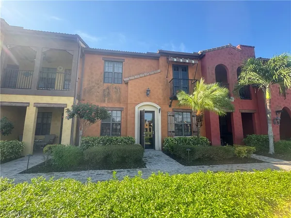 a front view of a house with a yard and potted plants