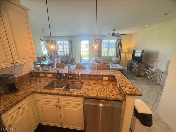 a kitchen with sink and view of living room