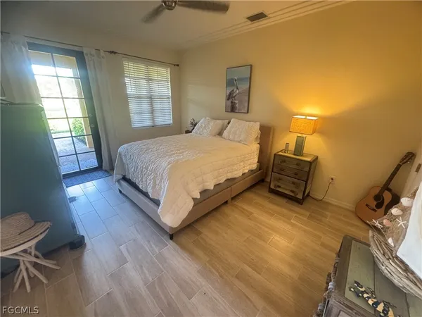 a spacious bedroom with a bed and wooden floor