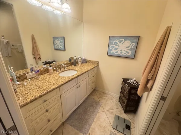 a bathroom with a granite countertop sink and a mirror