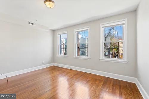 3742 12th Street Northeast, Unit 2 Washington, DC 20017 - Photo 1 of 8 a view of an empty room with wooden floor and a window