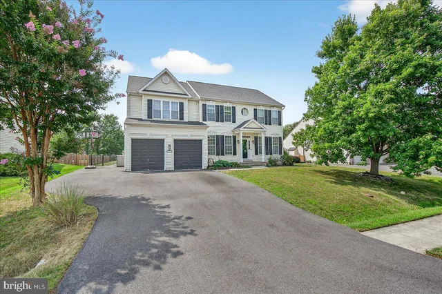 a front view of a house with a garden and trees