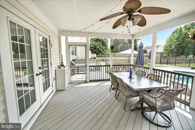 a view of an empty room with wooden floor and windows