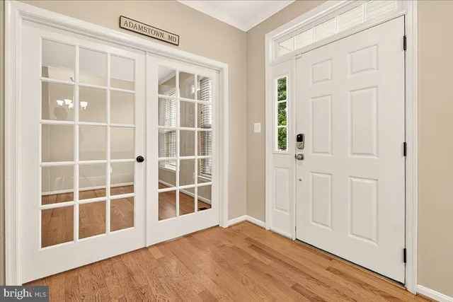 a view of an empty room with wooden floor and a fireplace