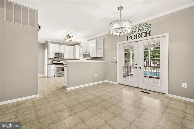 a kitchen with stainless steel appliances white cabinets white stove a microwave and a refrigerator