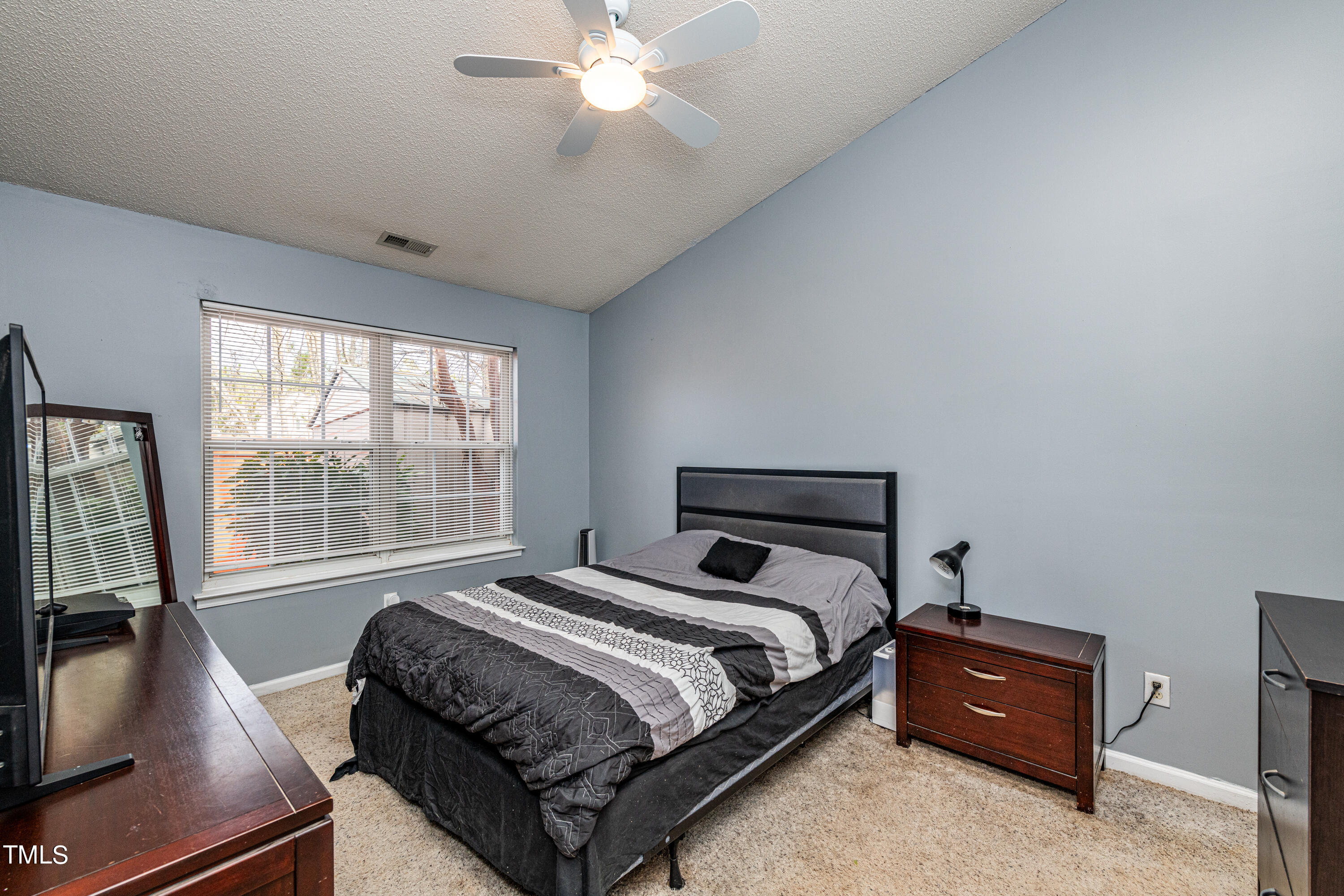 4225 Lake Woodard Drive Raleigh, NC 27604 - Photo 15 of 27 a bedroom with a bed and a flat tv screen on dresser