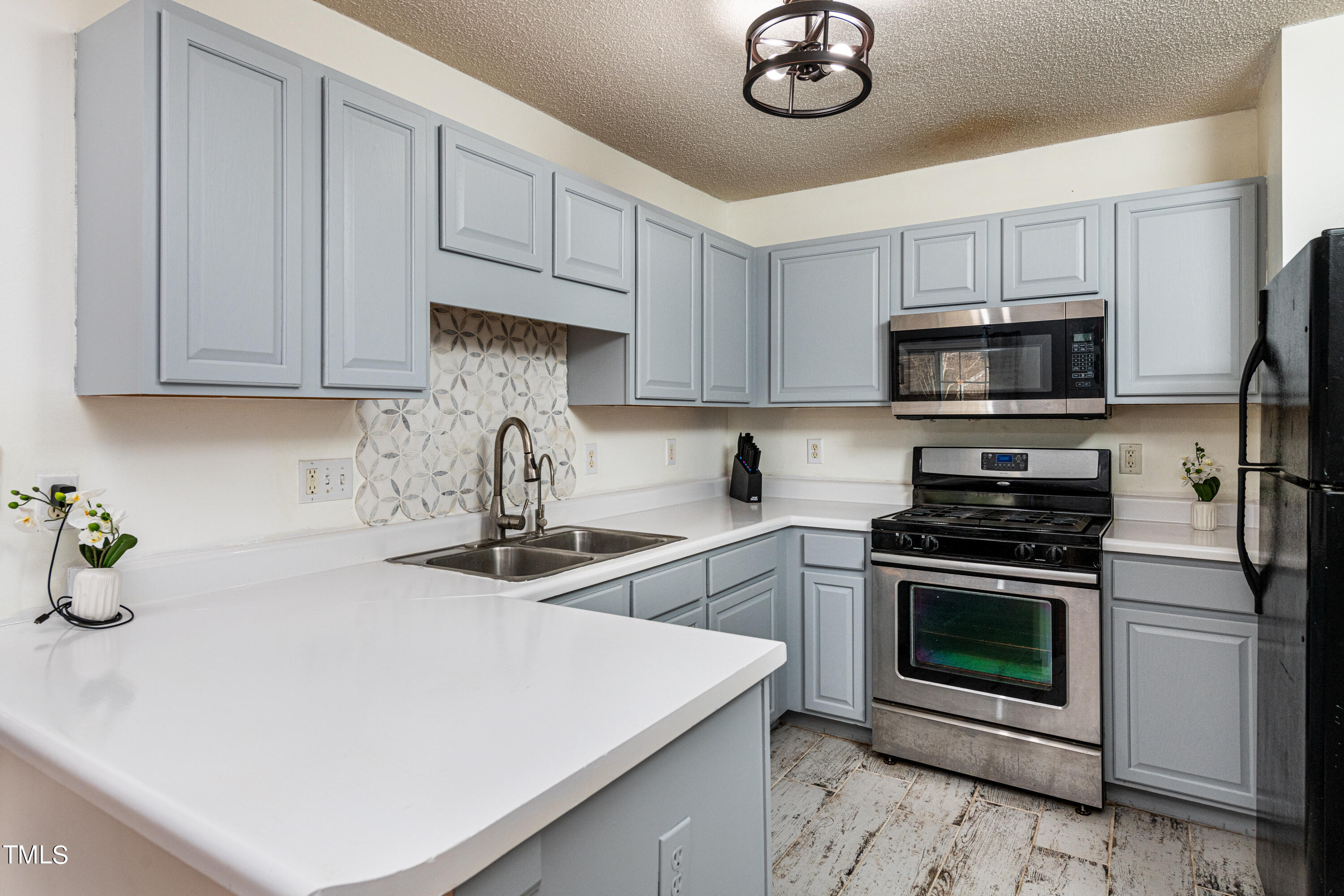 4225 Lake Woodard Drive Raleigh, NC 27604 - Photo 4 of 27 a kitchen with stainless steel appliances granite countertop a stove top oven a sink dishwasher and a microwave with cabinets