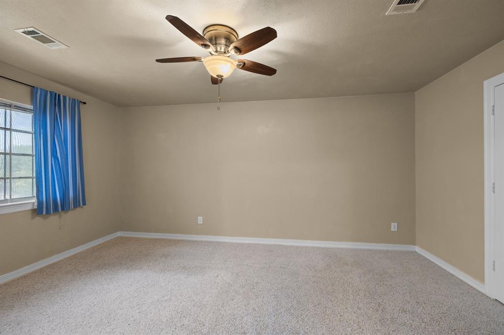 8049 Sunscape Lane Fort Worth, TX 76123 - Photo 32 of 37 an empty room with a chandelier fan and windows