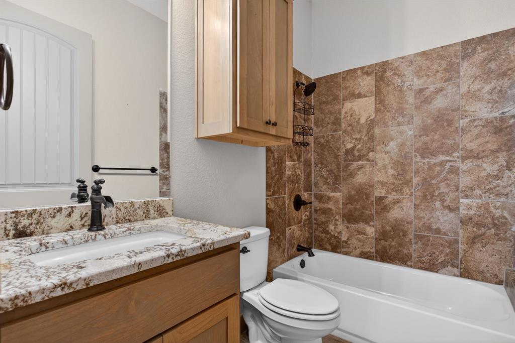 990 Doss Road Millsap, TX 76066 - Photo 24 of 39 a bathroom with a granite countertop sink toilet and shower