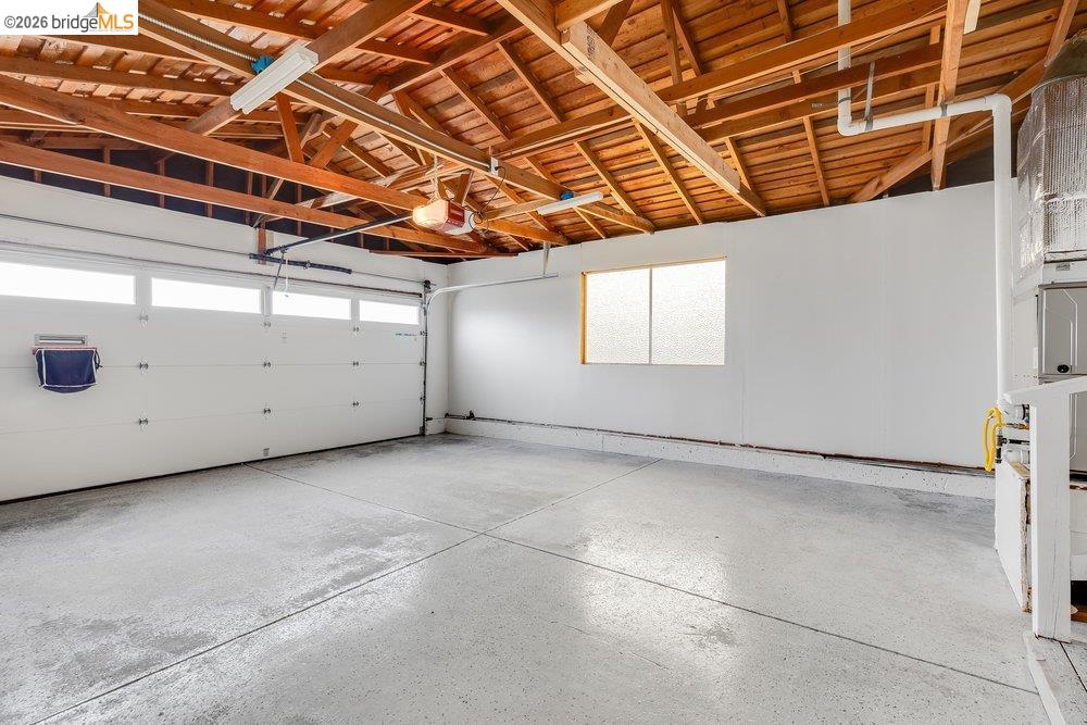 1298 Ribbon Street Foster City, CA 94404 - Photo 65 of 86 Garage with exposed wood beam ceiling, white walls, frosted glass window, and concrete flooring