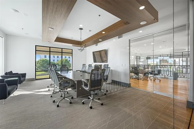 a living room with furniture floor to ceiling window and wooden floor