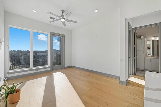 a view of an empty room with a window and a ceiling fan