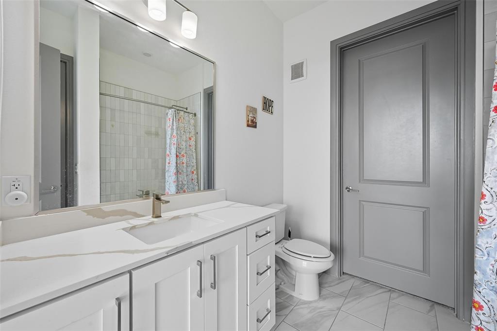 2700 Old Denton Road, Unit 3310 Carrollton, TX 75007 - Photo 7 of 21 a bathroom with a granite countertop sink a toilet and a large mirror