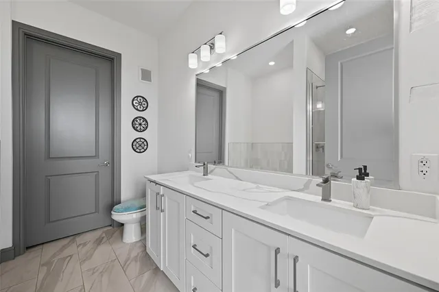 a bathroom with a sink a toilet and shower