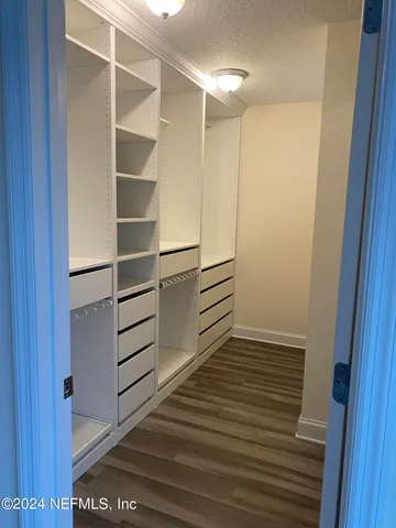 a view of walk in closet with empty racks