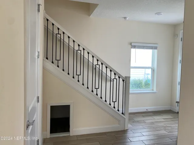 a view of staircase with wooden floor and white walls