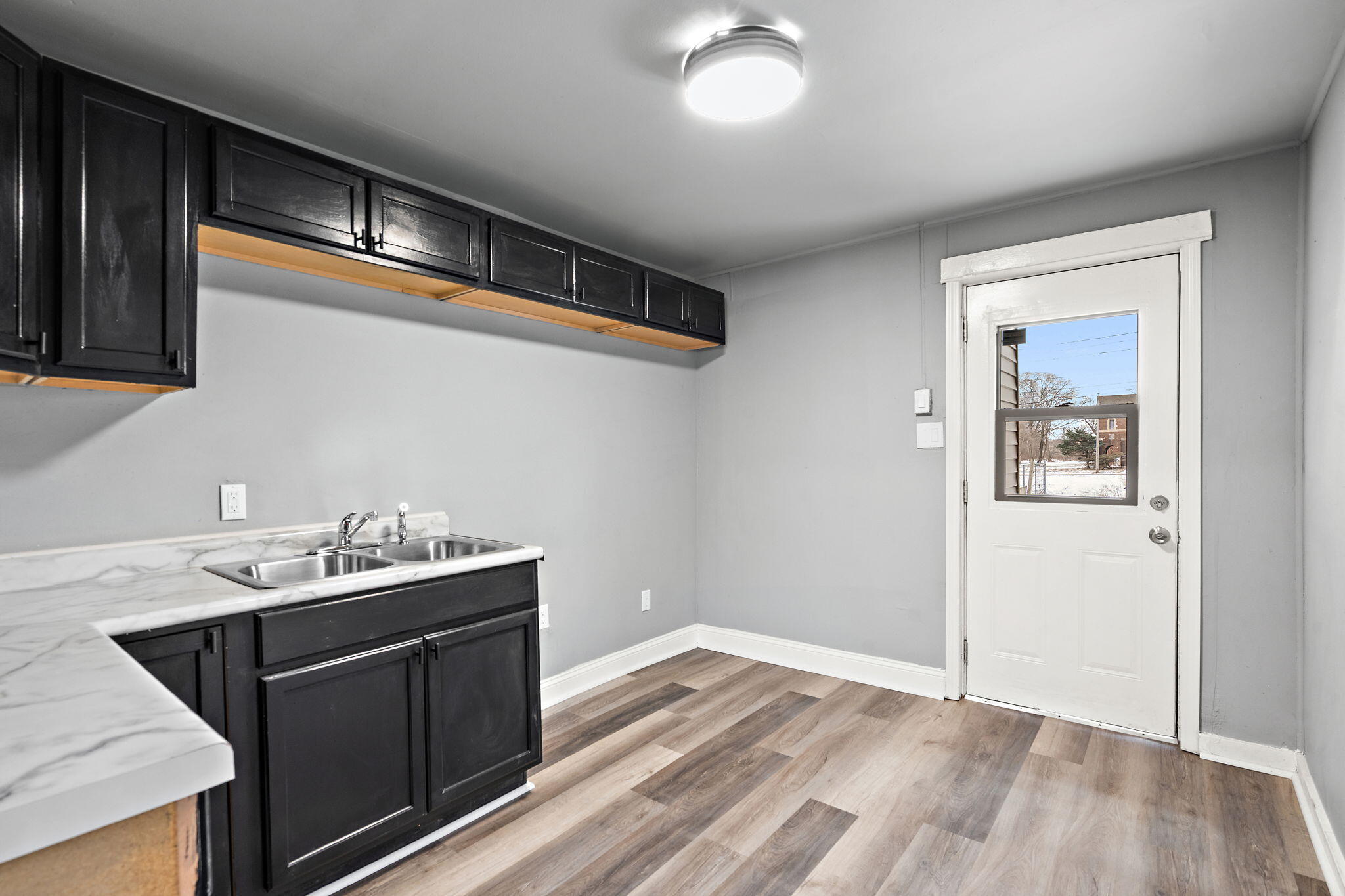 565 Jackson Street Gary, IN 46402 - Photo 9 of 24 a kitchen with a sink cabinets and wooden floor