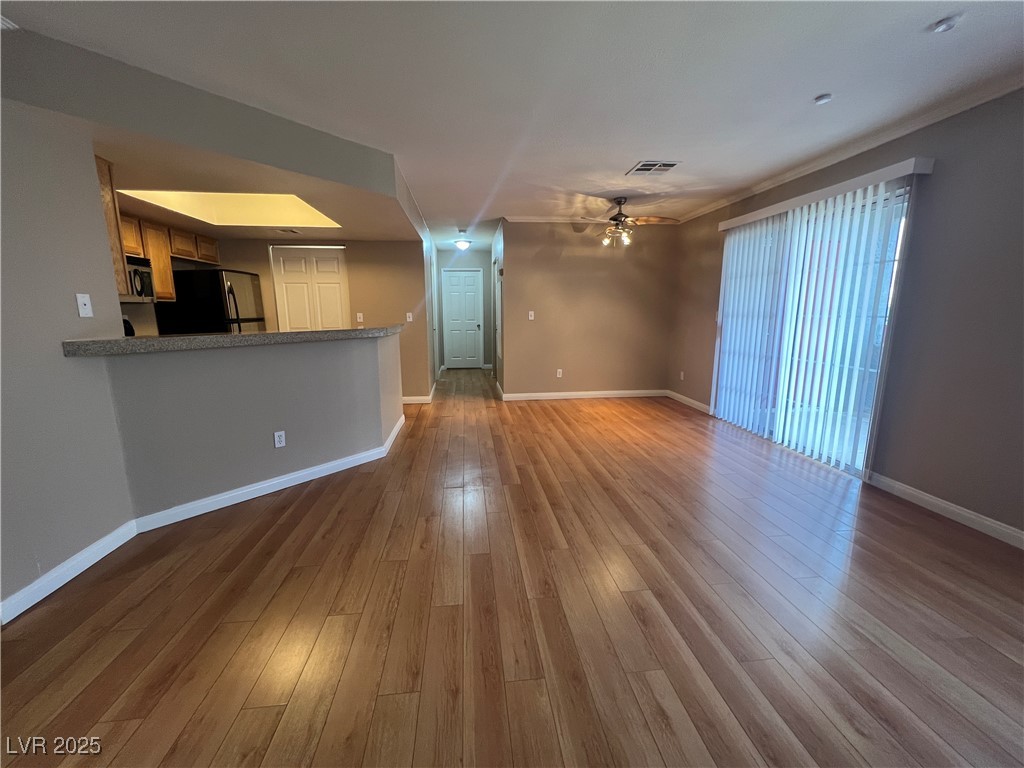 8600 West Charleston Boulevard, Unit 1060 Las Vegas, NV 89117 - Photo 3 of 14 Unfurnished living room featuring dark wood-style flooring and a ceiling fan
