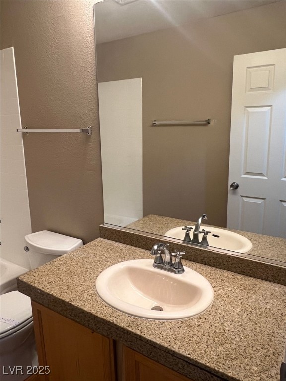 8600 West Charleston Boulevard, Unit 1060 Las Vegas, NV 89117 - Photo 9 of 14 Full bathroom featuring vanity, bathtub / shower combination, and a textured wall
