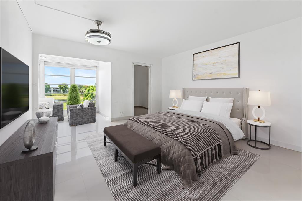 a bedroom with a large bed a flat screen tv and a couch