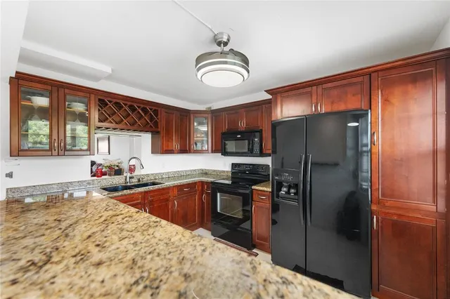 a kitchen with stainless steel appliances granite countertop a refrigerator a sink a stove and island