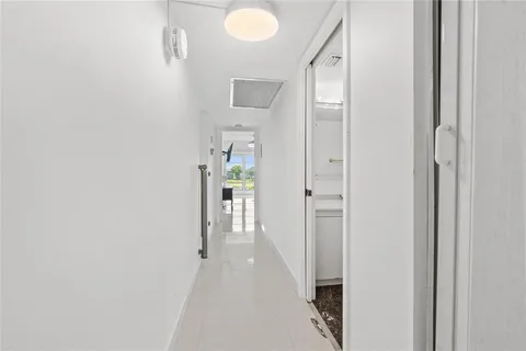 a view of a hallway with closet and a bathroom