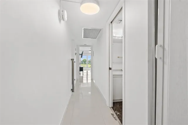 a view of a hallway with closet and a bathroom