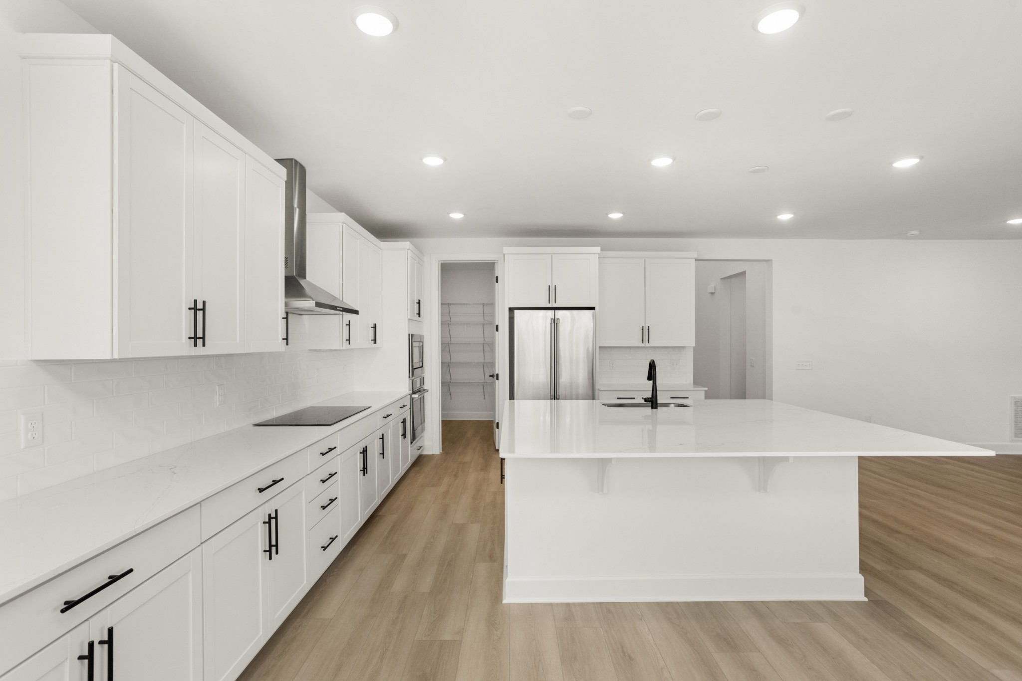 205 Acmon Blue Road Mount Juliet, TN 37122 - Photo 18 of 64 a large white kitchen with wooden floors stainless steel appliances and a sink