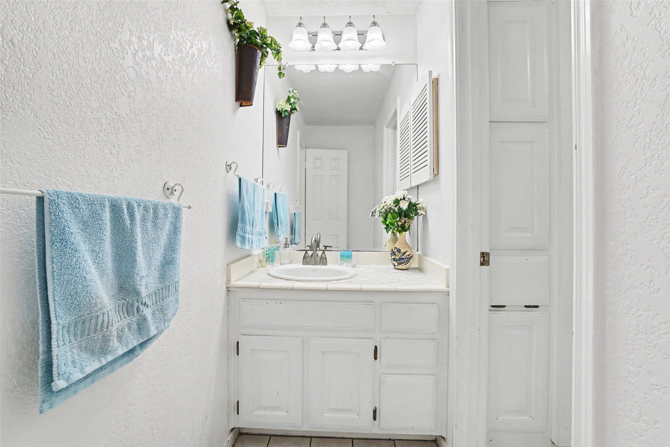 110 South Ridge Circle Georgetown, TX 78628 - Photo 23 of 37 Bathroom vanity with white cabinetry, a single basin sink, and a tiled countertop
