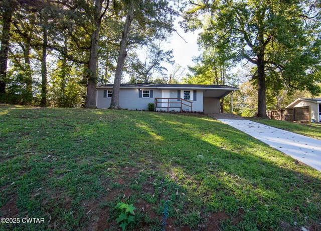 a view of a house with yard and tree s