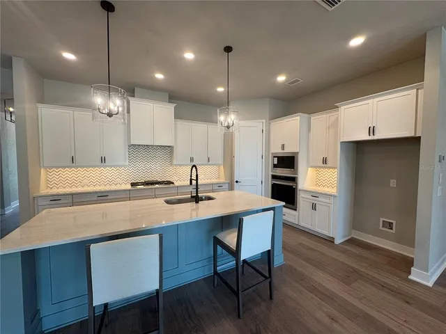 a kitchen with a sink refrigerator and cabinets