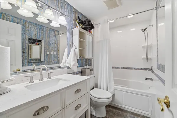 a bathroom with a sink a toilet and a large mirror