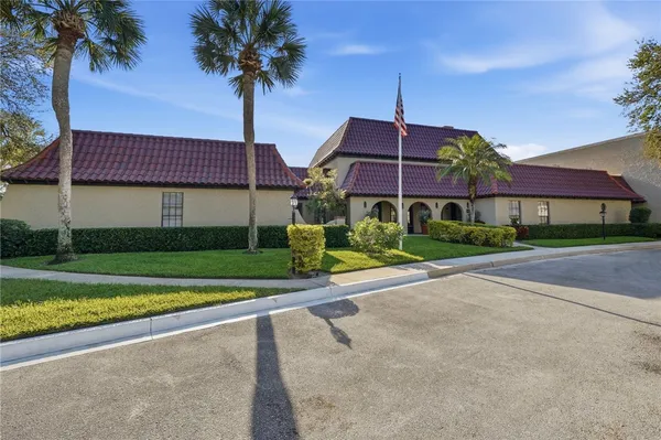 a front view of a house with a yard and palm trees