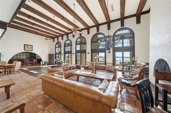 a living room with furniture a fireplace and lots of windows
